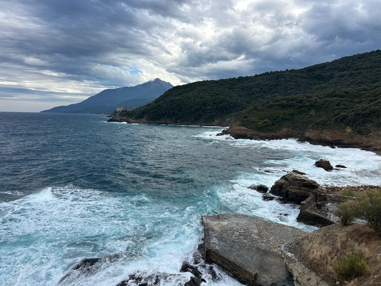 The shore of Mount Athos with the peak in the clouds