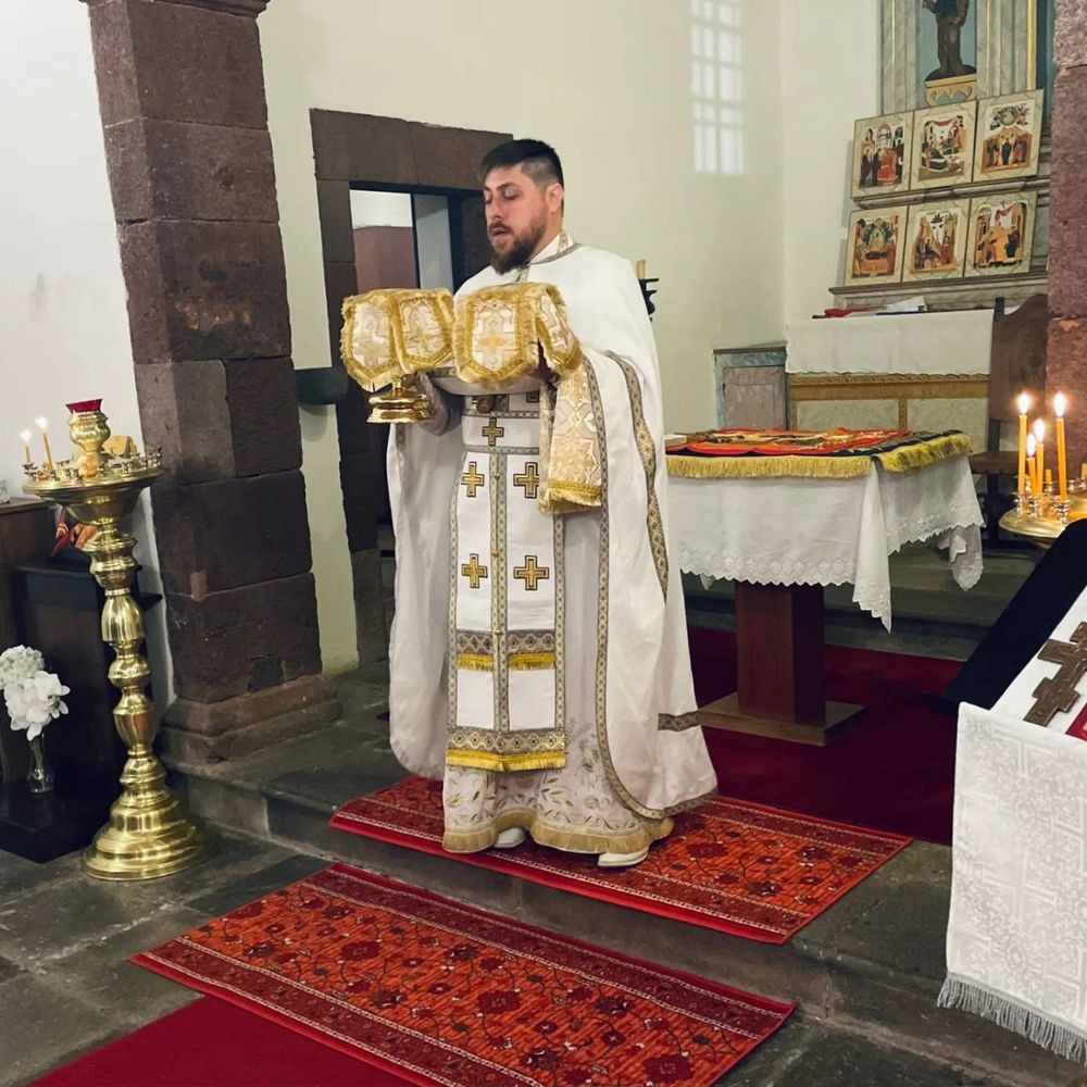 Священник в белом облачении в часовне на Мадейре во время Литургии